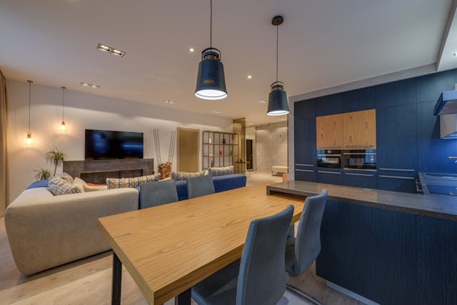 Modern open-concept kitchen and living room with wood and navy accents.