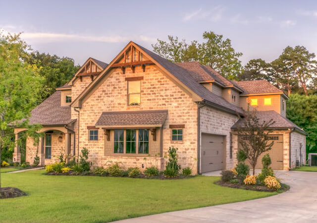 Beautiful stone exterior home with manicured lawn and rustic architectural accents in Oakville, Ontario.