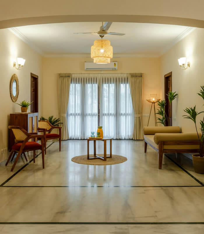 Elegant living room with a minimalist design featuring marble flooring, warm beige walls, and soft ambient lighting.